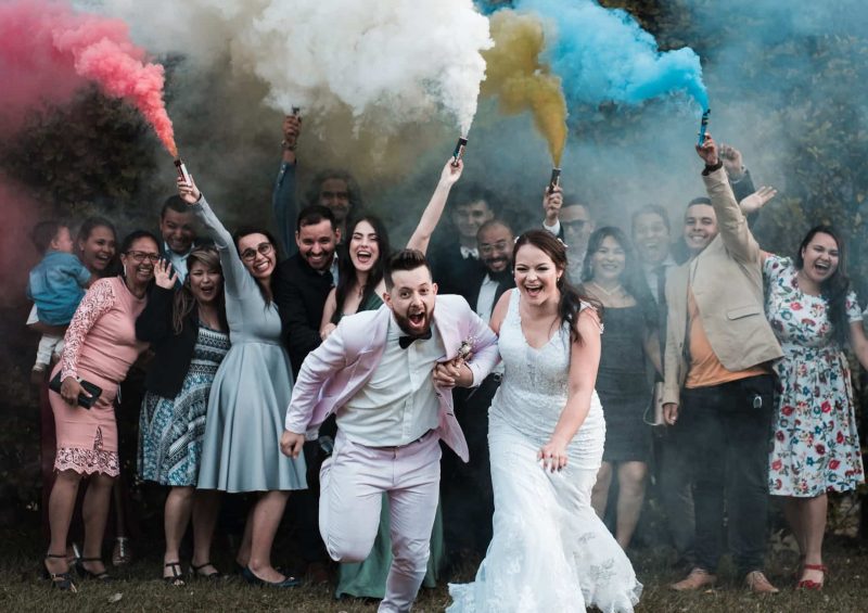photo of couple holding hands while running away from people