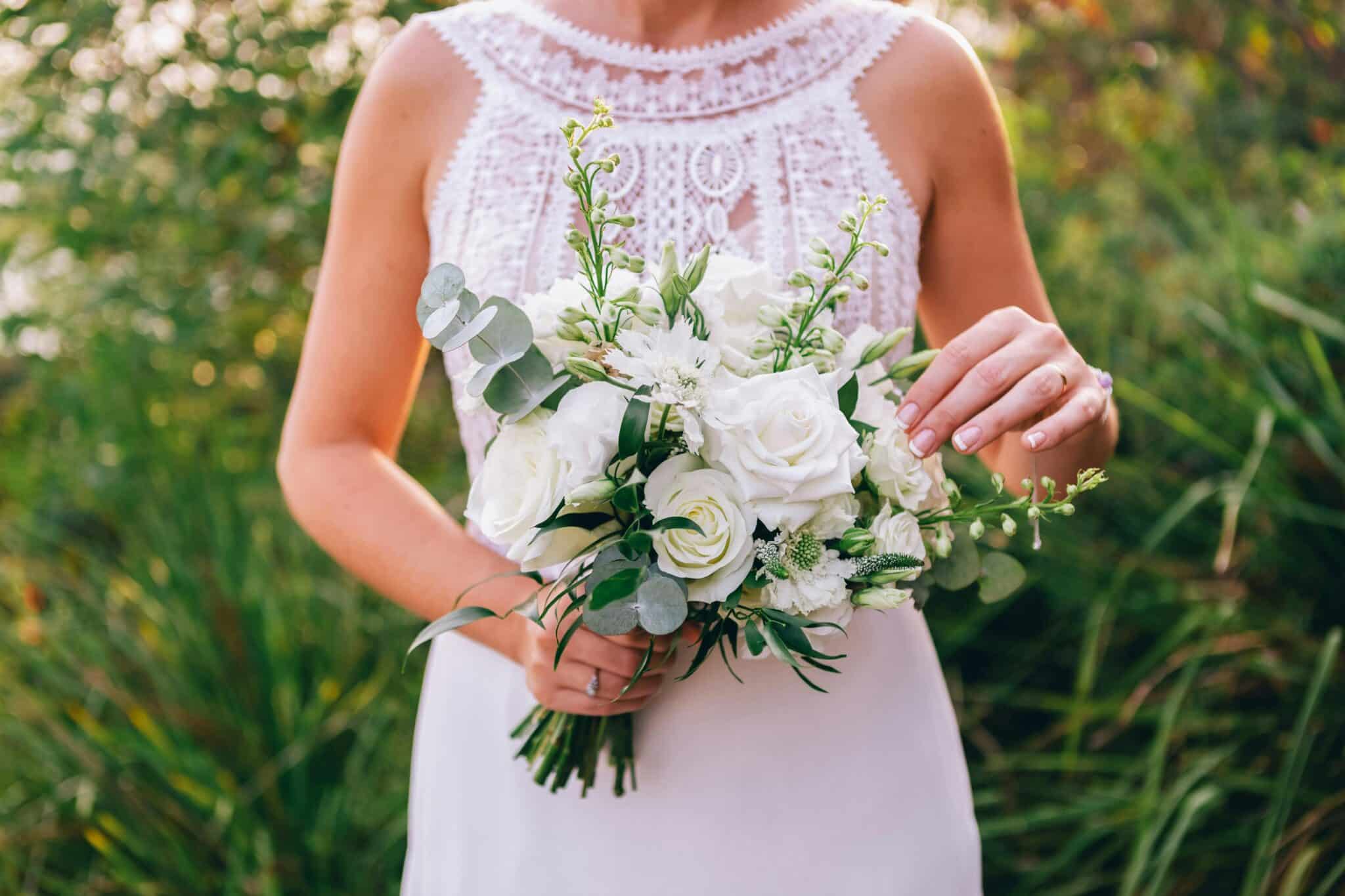 mariée qui tient un bouquet qui fait partie des accessoires indispensables pour la mariée