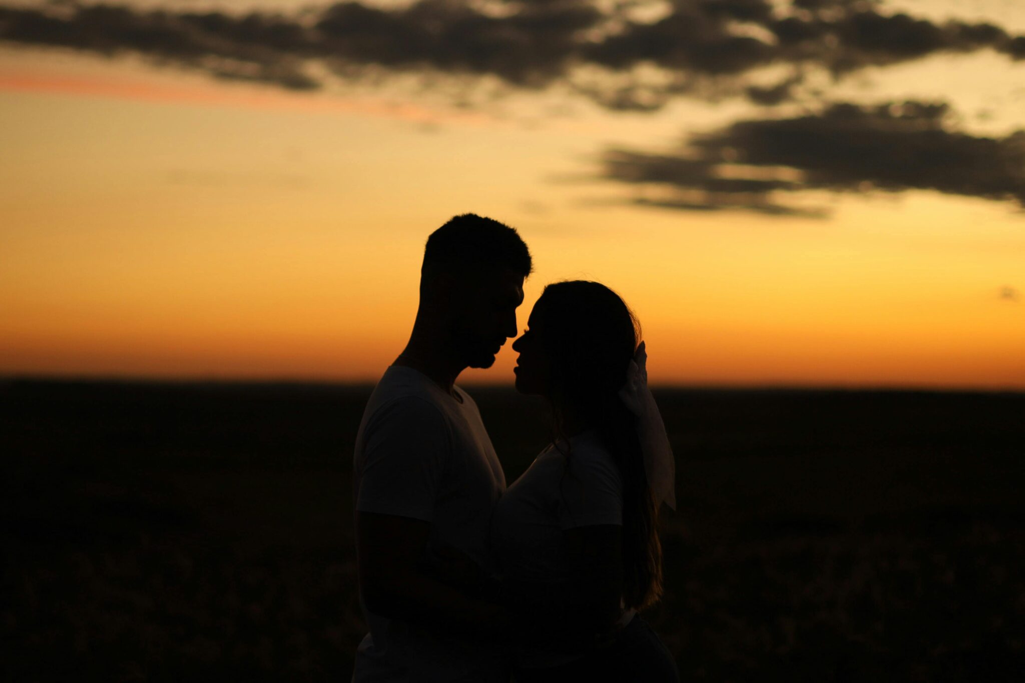 Un couple face à face au coucher de soleil